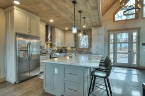 A spacious kitchen with a large island, stainless steel appliances, and a rustic ceiling. - 4 Dancing Bears|Mtn Views+Hot Tub+ Design (Blue Ridge)