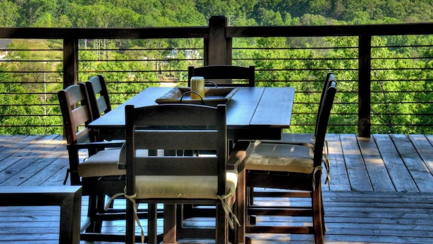 A wooden deck with a table and chairs overlooking a forested landscape. - 4 Dancing Bears|Mtn Views+Hot Tub+ Design (Blue Ridge)