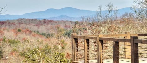 A wooden deck with a view of a mountainous landscape.