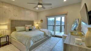 A bedroom with a bed, bedside tables, a ceiling fan, a window with a view, and a built-in bench. - 4 Dancing Bears|Mtn Views+Hot Tub+ Design (Blue Ridge)