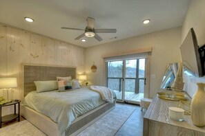 A bedroom with a bed, bedside tables, a ceiling fan, a window with a view, and a built-in bench. - 4 Dancing Bears|Mtn Views+Hot Tub+ Design (Blue Ridge)