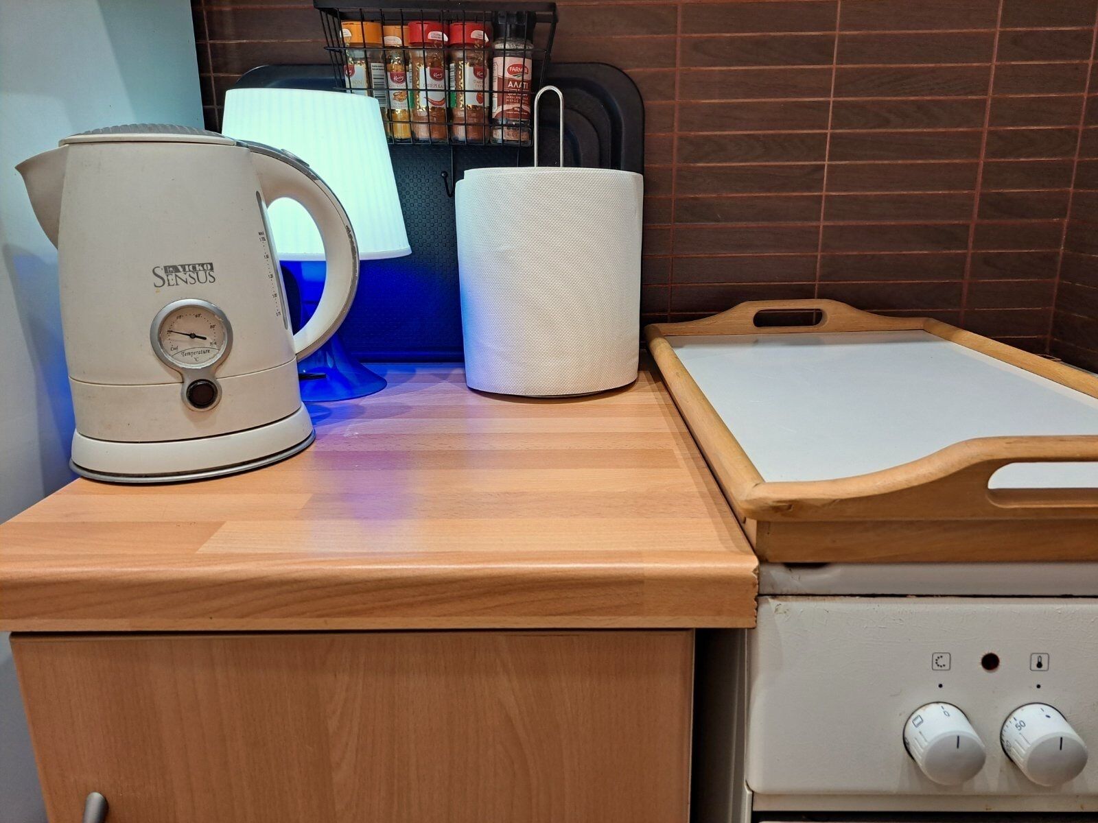 Eine Küche mit Kaffeemaschine, Papierhandtuchhalter und einer Holzausziehtafel.