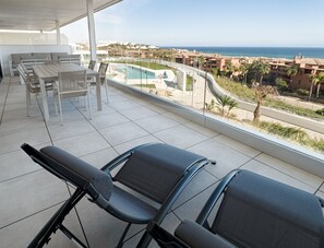 Een balkon met uitzicht op zee en een zwembad.