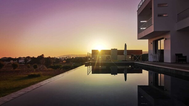 A modern building with a pool reflecting the sunset. - Modern Luxury Villa near Lachi (Prodromi)