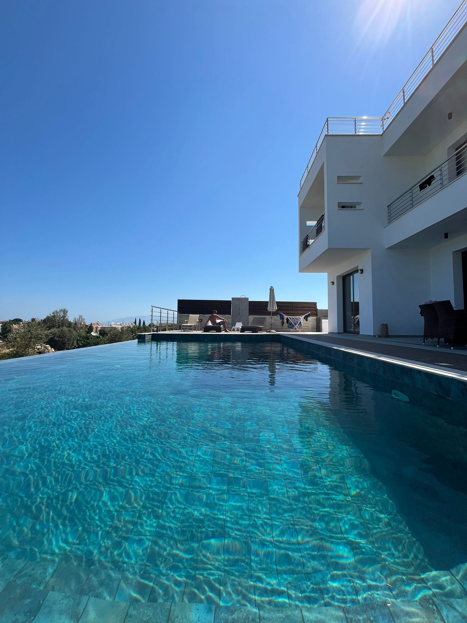 Une piscine d’un bleu éclatant, avec un bâtiment moderne en arrière-plan.