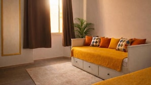 Une chambre à coucher avec un lit, une plante en pot et une fenêtre avec des rideaux.