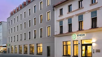 Ein mehrstöckiges Hotelgebäude mit großen Fenstern und einem Schild für 'elaya hotels'.