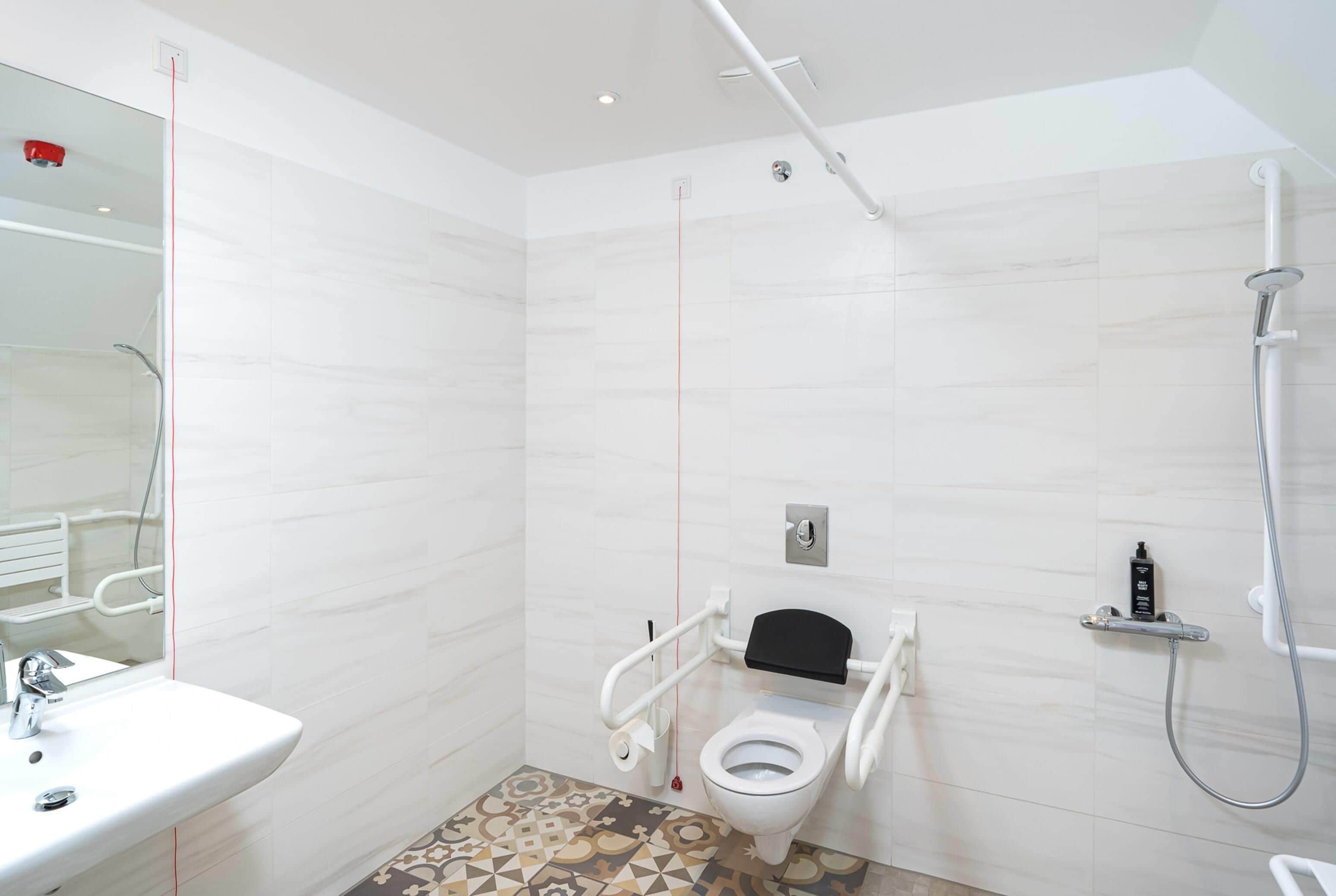 A modern bathroom with a white toilet, a shower, and a sink.