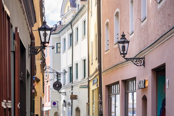 Una calle estrecha flanqueada por edificios con arquitectura tradicional y faroles colgantes.