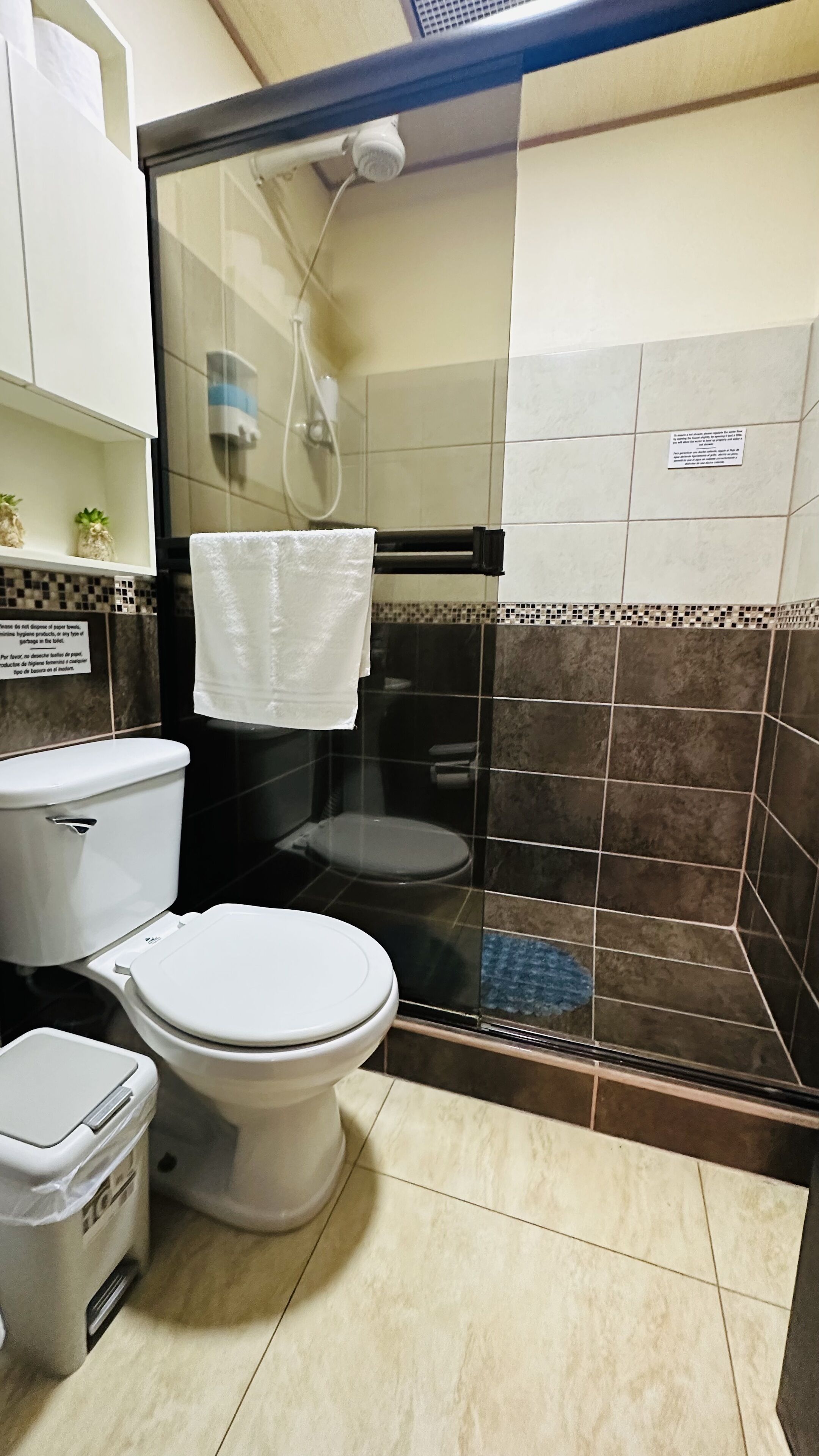 A bathroom with a toilet, a bidet, and a glass-enclosed shower area.
