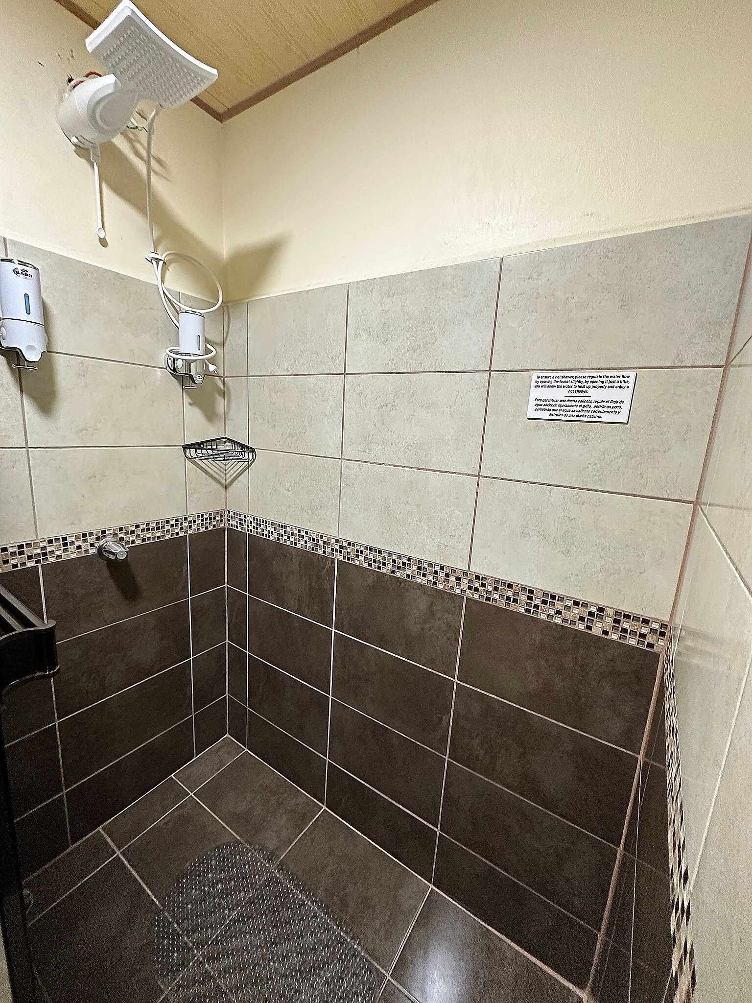Une salle de bain équipée d’une douche, d’un porte-serviettes et d’un sèche-mains.