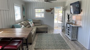 A cozy living area with a wooden dining table, a cushioned sofa, and a patterned rug.
