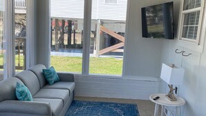 A living room with a grey sofa, blue rug, and a blue chair.