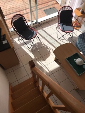 A staircase leading to a room with two chairs and a table with a teapot. - Sunny T3 duplex, close to beaches, casino, golf course and Thalasso spa (Quiberon)