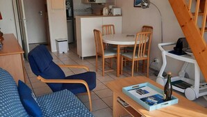 Ein kompakter Wohnbereich mit Küchenzeile, Essplatz und einer Sitzecke mit Sofa und Sesseln.