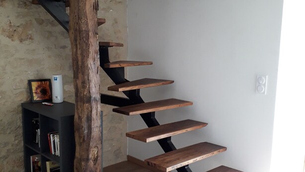A spiral staircase with wooden steps and black metal supports, leading to a higher floor. - Country house with lots of outdoor space (Beauregard)