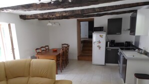 A compact living space with a dining area, kitchen, and a sofa. - Country house with lots of outdoor space (Beauregard)
