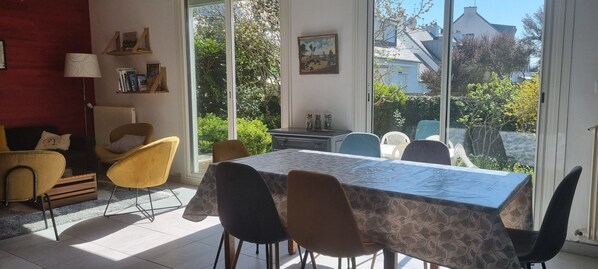 A dining area with a table and chairs, a radiator, a lamp, and a bookshelf.