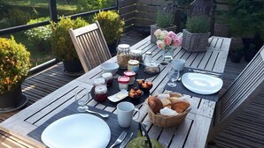 A wooden table set for a meal with plates, cutlery, and food items. - Villa Marguerite (Saint-Omer)