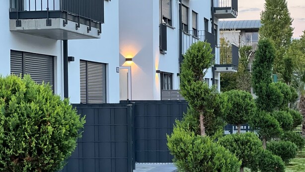 A modern apartment building with balconies, a gated entrance, and well-maintained greenery. - The Residences - Apartments Frankfurt (Offenbach am Main)