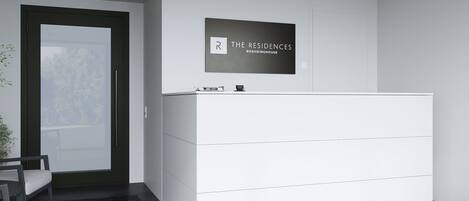 Balcão de recepção moderno e minimalista, com uma placa emoldurada acima.