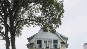 A two-story house with a front porch and a staircase leading to the entrance. - Beautiful 3600sqft Cottage on Lake Maxinkuckee in Culver Indiana. (Culver)