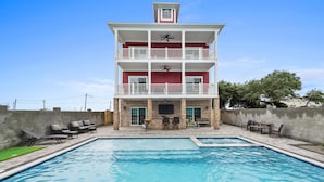 A multi-story building with a swimming pool in front.