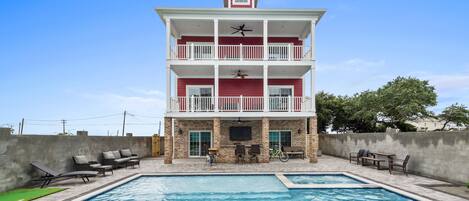 A multi-story building with a swimming pool in front.