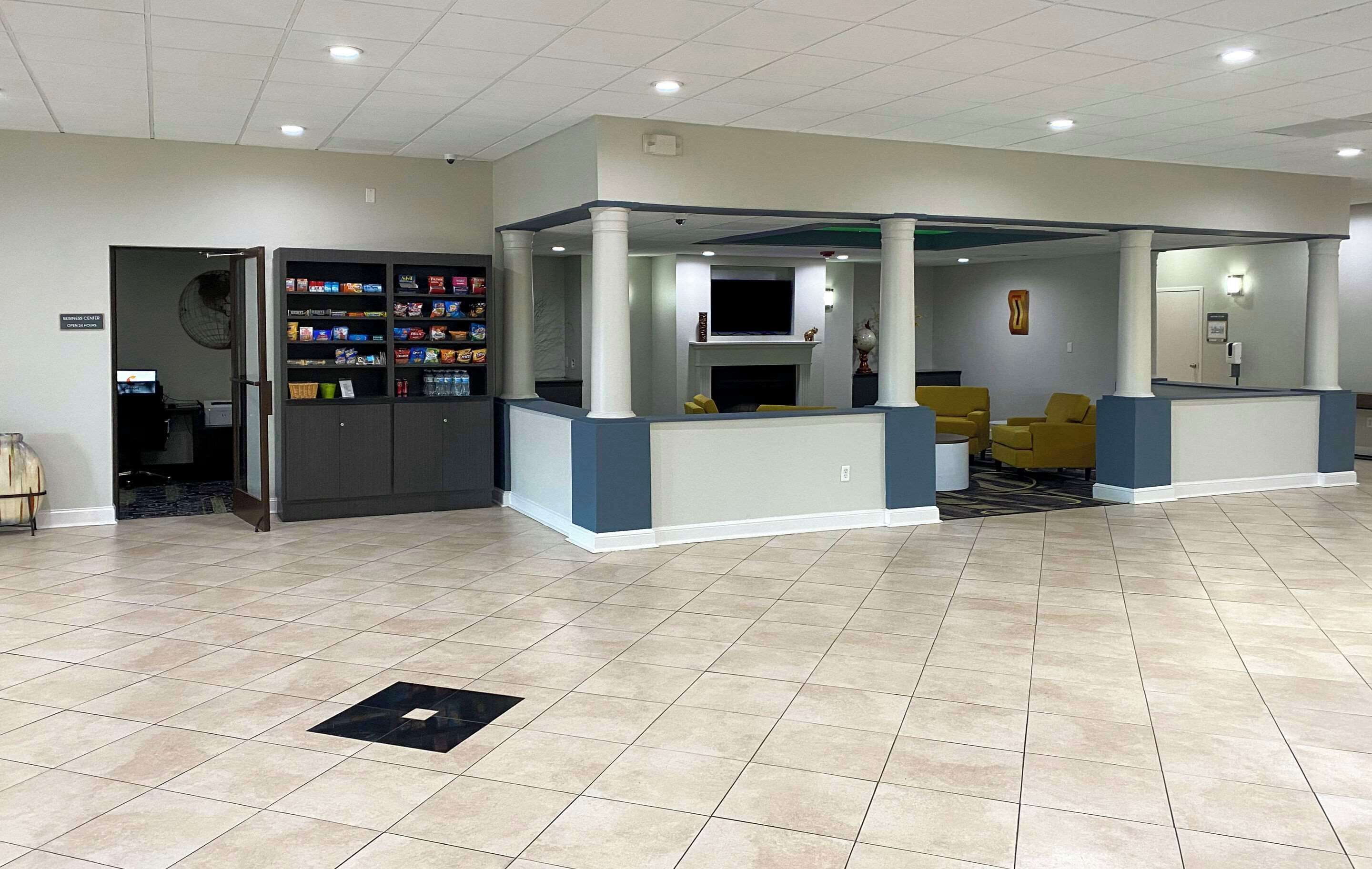 A spacious lobby with a reception desk, seating area, and a vending machine.