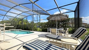 A covered outdoor area with a pool, lounge chairs, and a table. - Spacious pool home with games room and hot tub (heating included) (Davenport)