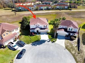 Un quartier résidentiel avec des maisons à deux étages, une allée et une voiture garée.