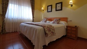 Un dormitorio con cama, mesita de noche y lámparas fijadas a la pared.