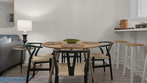 A dining area with a round table, four chairs, a chandelier, and a bar stool. - 🐟1st Floor with Bikes-Coach's Sand Dollar (Santa Rosa Beach)