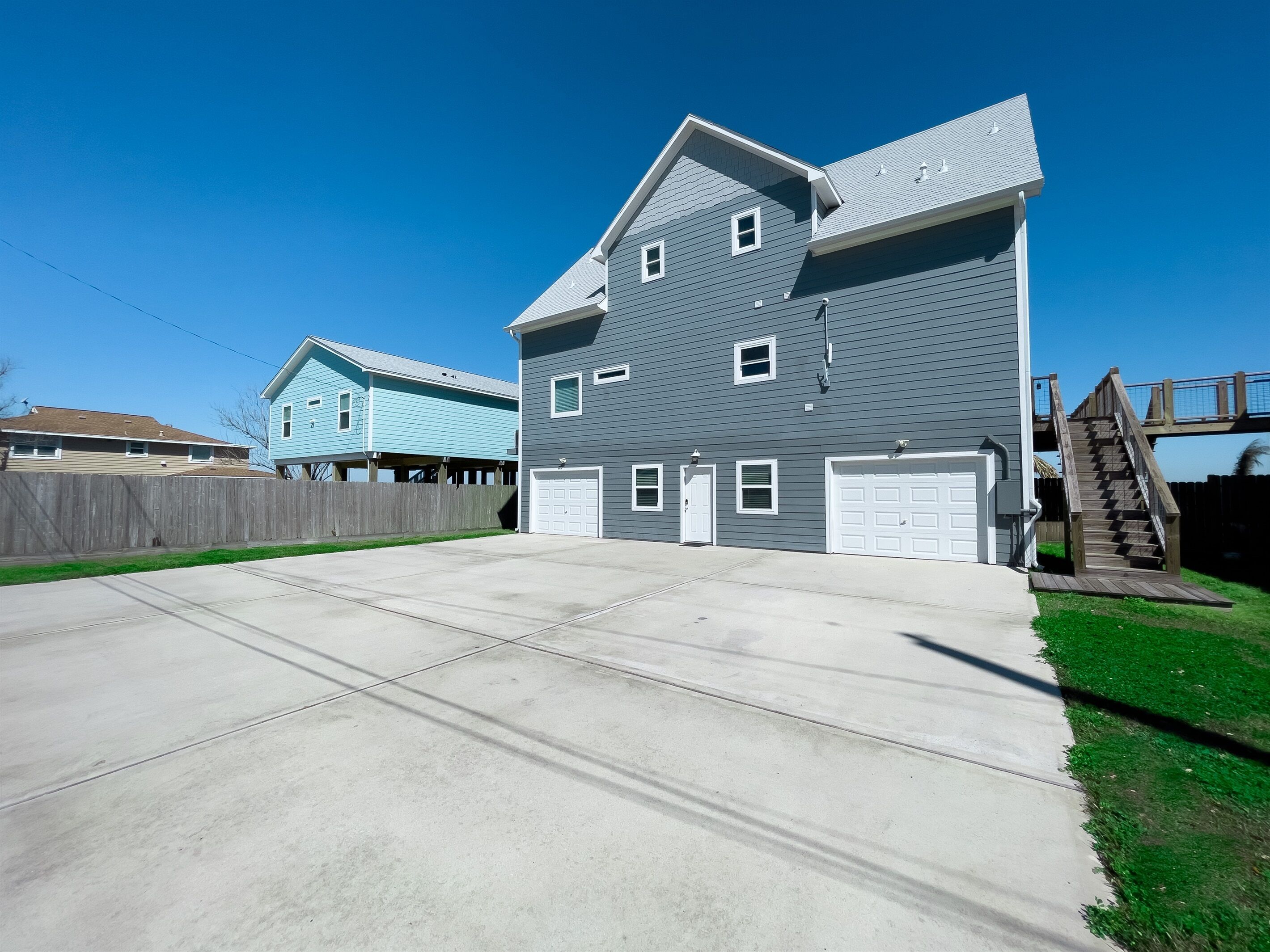 A two-story residential building with a garage and a covered staircase.
