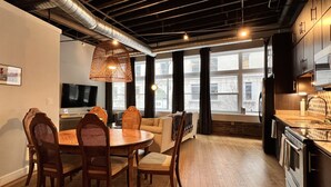 A modern kitchen with dark cabinetry, a stainless steel refrigerator, and a built-in oven. - Ambrose Lofts - 1 bedroom overlooking 4th Ave Downtown (Nashville)