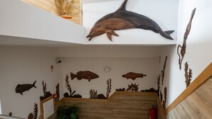 A staircase with wooden steps and a wall decorated with marine life murals. - Nereida (Horta)