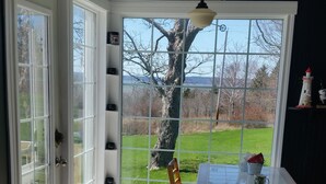 Une cuisine donnant sur un arbre et une pelouse, grâce à une grande fenêtre.