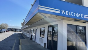 Un edificio con un cartel que dice 'WELCOME', número 1051, y un vestíbulo techado.