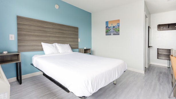 Una habitación de hotel moderna con una cama grande, un escritorio y una silla.