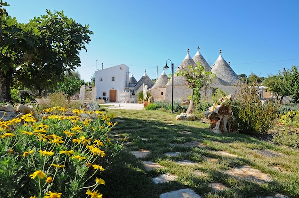 Un pueblo tradicional con casas de piedra y un edificio central blanco.