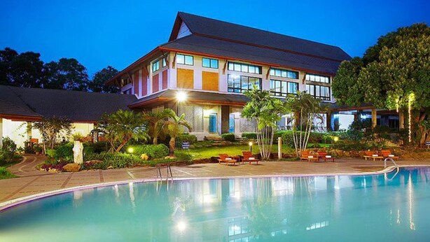 Un grand bâtiment avec une piscine devant.