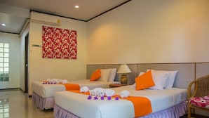 Une chambre d’hôtel avec deux lits, une table de chevet, une lampe et un élément décoratif mural.