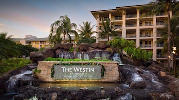 Un resort con una cascada, un letrero que dice 'The Westin Ka'anapali Ocean Resort Villas' y un edificio de varios pisos con balcones.