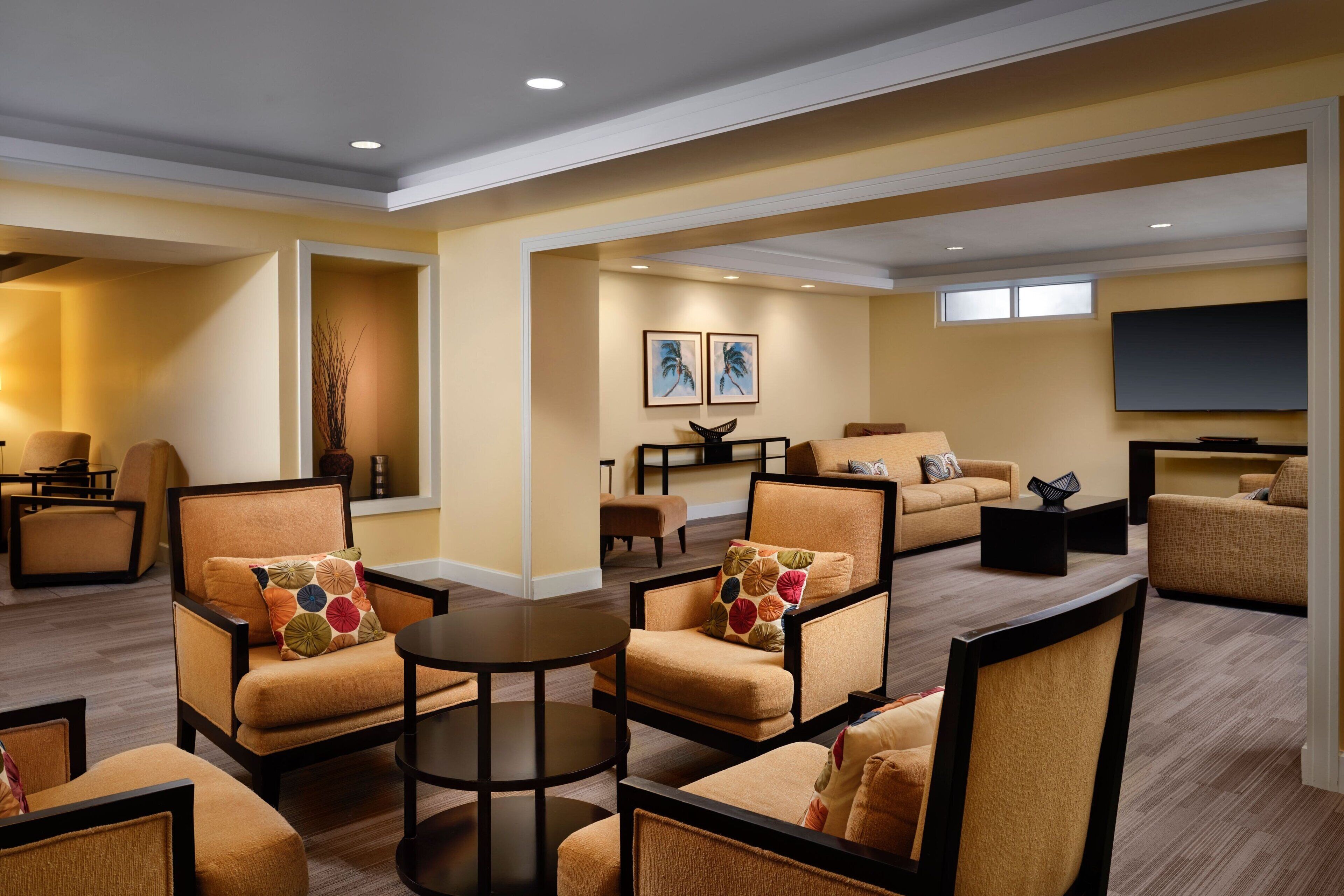 Amplia sala de estar con diversas opciones de asiento, incluyendo sofás y sillones, dispuestas alrededor de una mesa de centro.