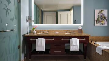 Un baño moderno con lavamanos doble, un espejo grande y una bañera.