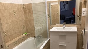 Un baño con bañera, lavabo y espejo.