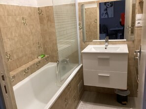 Ein Badezimmer mit einer Badewanne, einem Waschbecken und einem Spiegel.