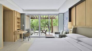 A modern bedroom with a large bed, a desk, and a balcony with outdoor seating.