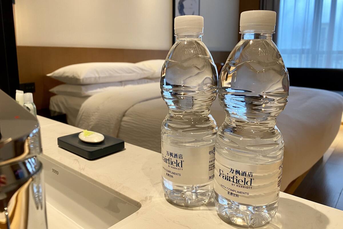 Zwei mit 'Fairfield by Marriott' beschriftete Wasserflaschen auf einem Hotelanreisetisch.