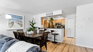 A modern apartment with a dining area, kitchen, and a living room. - Compass Pointe Condominium - Steps to downtown, close to Lake Michigan (Grand Haven)